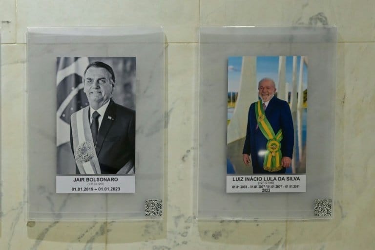 Portraits of former Brazilian president Jair Bolsonaro and current President Luis Ignacio Lula da Silva in the presidential palace in Brasilia / AFP