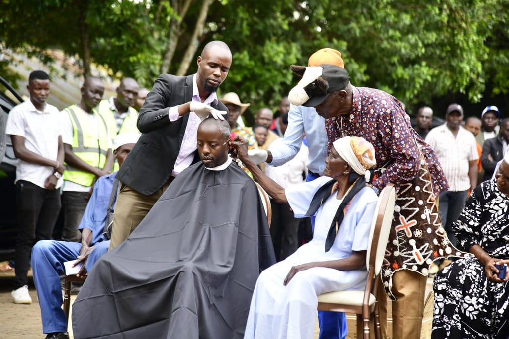 A grandmother performs the symbolic shaving ritual on Raila Junior, marking renewal and the assumption of responsibility.