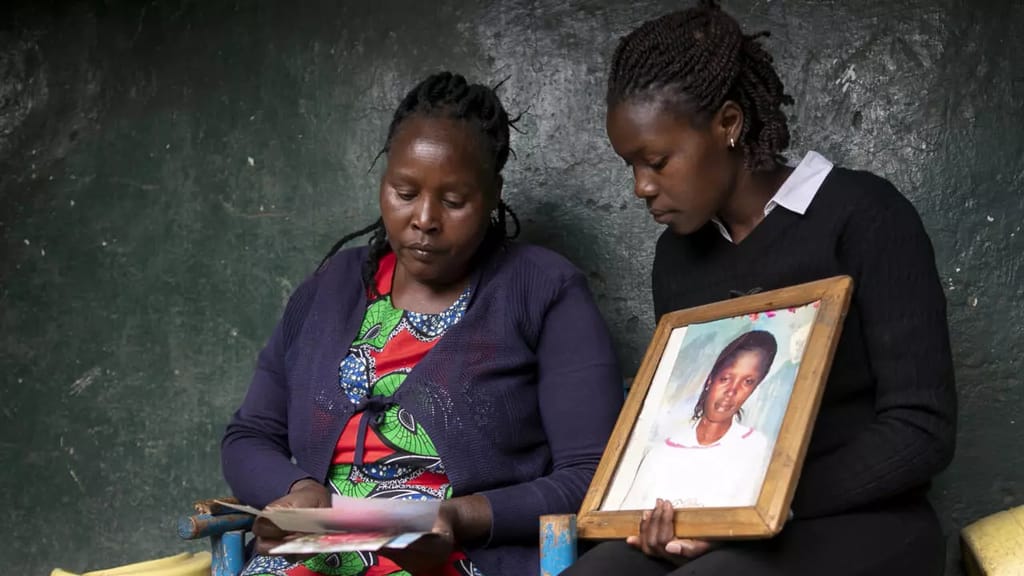 Agnes Wanjiru's sister Rose and another relative hold a picture of the young mother, who was found dead in 2012. AFP