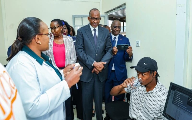 Samson Mutua receives the jab as Health Cabinet Secretary Aden Duale looks on. (Photo: MoH)